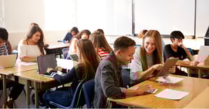 Tonårsstudenter i klassrummet som arbetar tillsammans