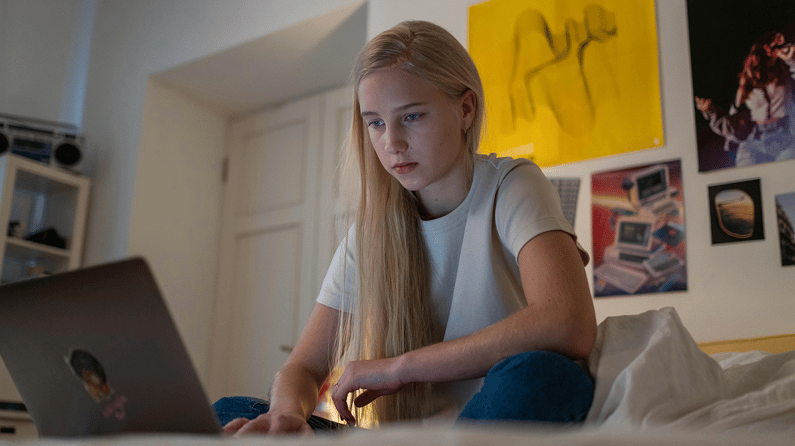 Barn på bærbar PC på rommet sitt