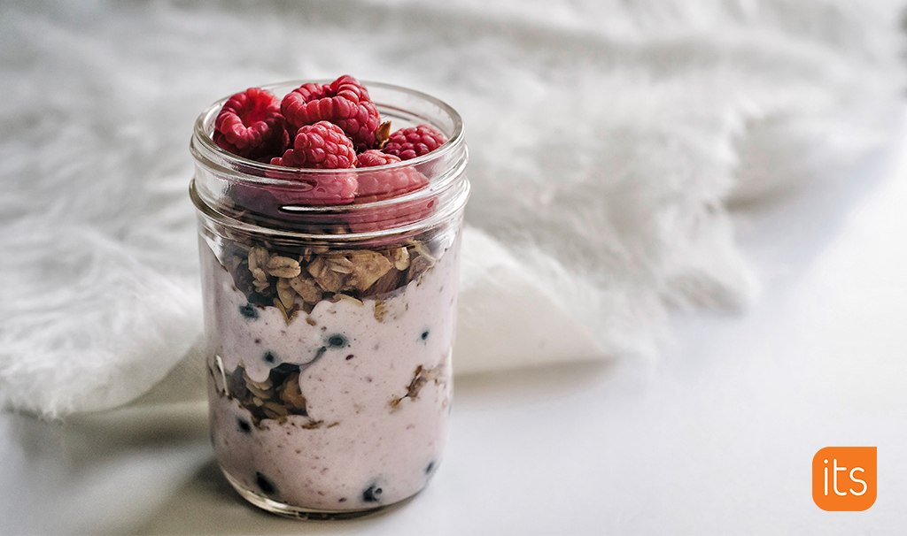 Oatmeal in a mason jar with berries on top.