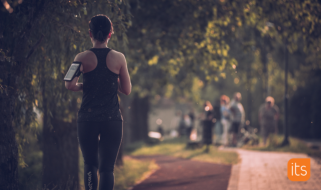 A woman running on a trail in a park.