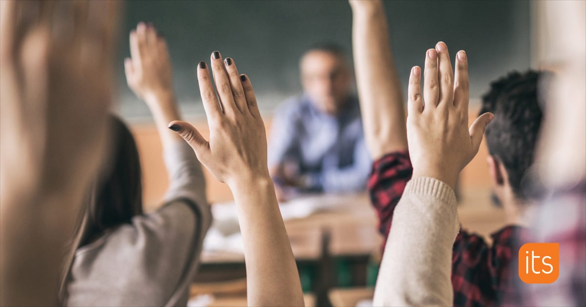 classroom students with hands raised