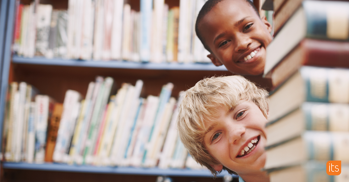 Photo of two happy students in the library.