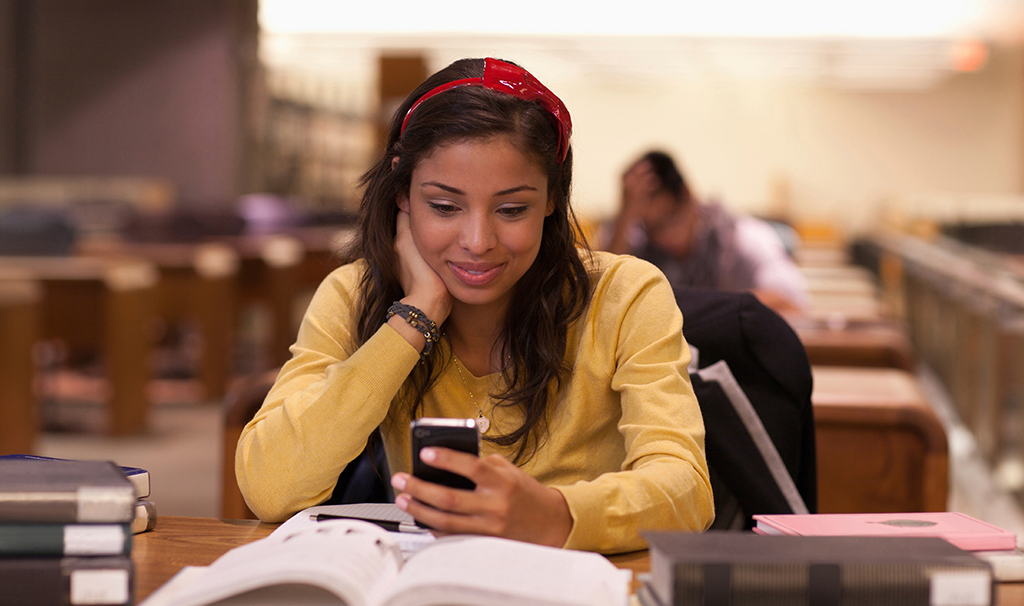 Woman studying and looking at phone