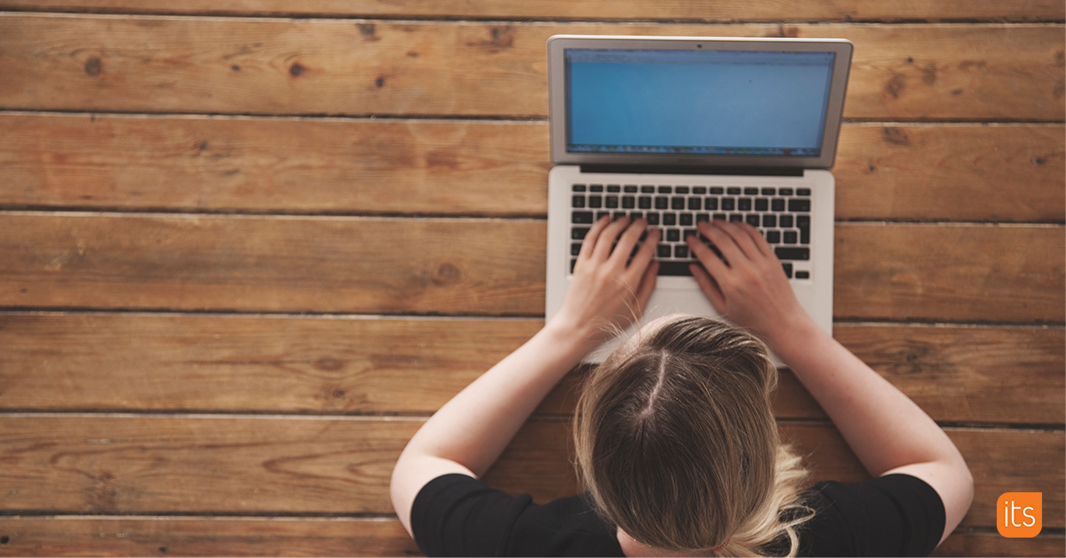 Photo of a teacher typing on a computer.