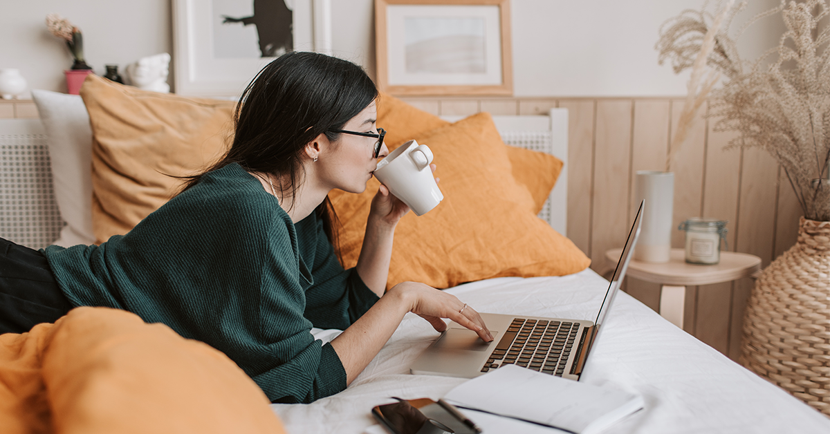 woman working on laptop, while drinking coffee